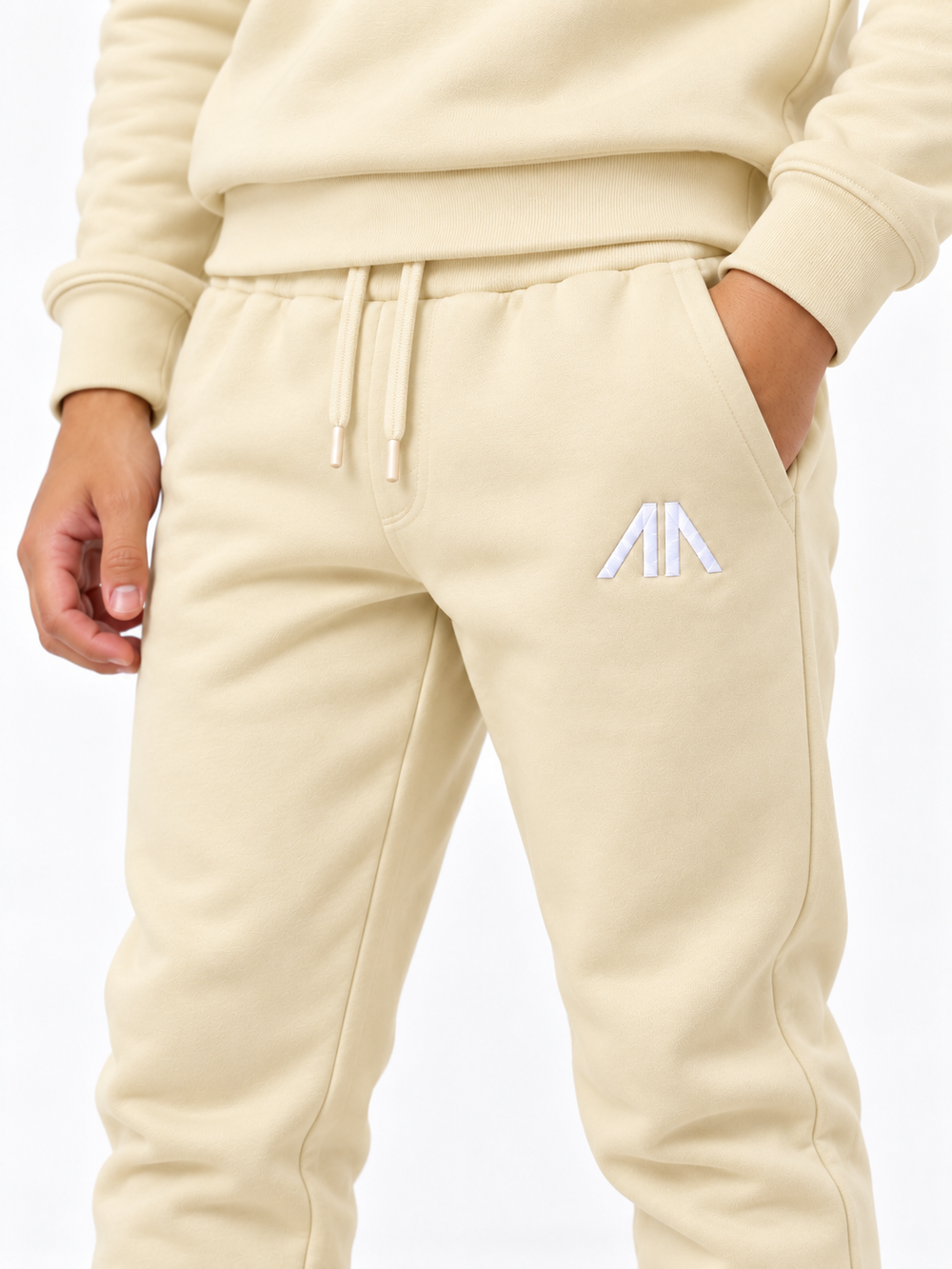 Close-up geborduurd Affinia logo op de broek, kinder trainingspak licht geel