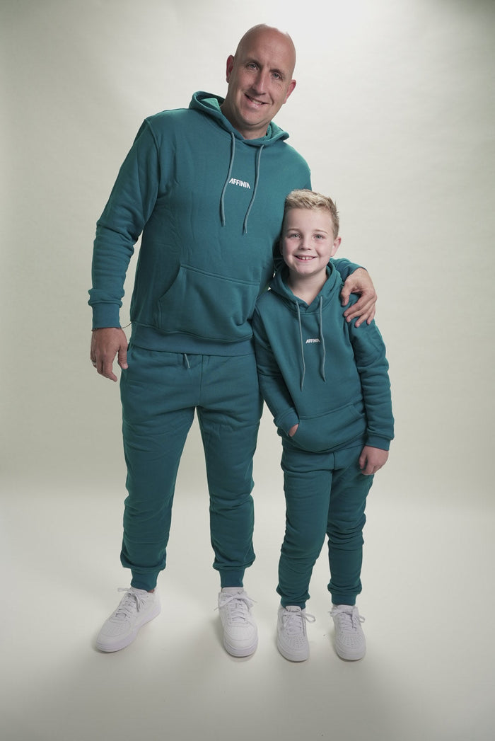 Vader en zoon in matching Trainingspak Petrol